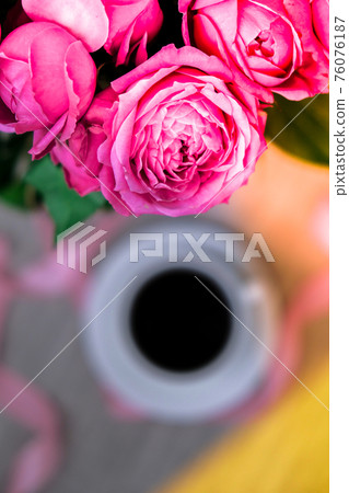 Cup of coffee and pink roses. Holiday concept, bouquet of roses for a birthday, bouquet of flowers in the morning breakfast. 76076187