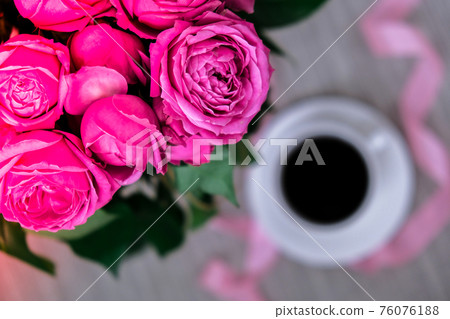Cup of coffee and pink roses. Holiday concept, bouquet of roses for a birthday, bouquet of flowers in the morning breakfast. Cup of coffee and pink roses. Holiday concept, bouquet of roses for a birthday, bouquet of flowers in the morning breakfast. 76076188