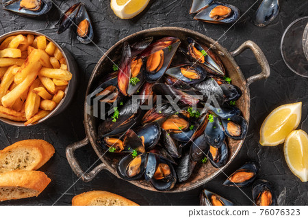 Mussels with potatoes, lemons, and toasted bread, top shot Mussels with potatoes, lemons, and toasted bread, top shot 76076323