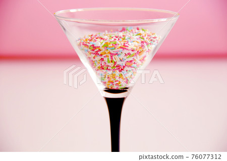 cocktail concept, sweet multicolour candies in martini glass cocktail concept, sweet multicolour candies in martini glass 76077312
