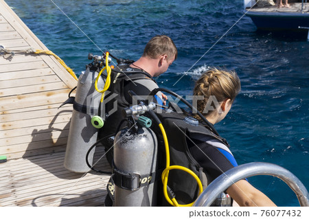 Two divers prepare for diving.  76077432