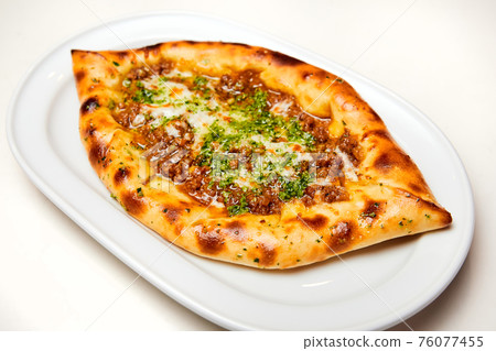 Khachapuri meat on a white plate. Close-up, selective focus. Khachapuri meat on a white plate. Close-up, selective focus. 76077455