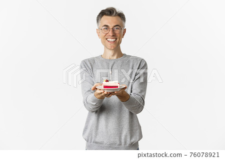 Portrait of happy middle-aged man congratulating and wishing happy birthday, giving you b-day cake and smiling, standing over white background Portrait of happy middle-aged man congratulating and wishing happy birthday, giving you b-day cake and smiling, standing over white background 76078921