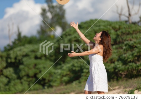 Girl throwing a hat into the sky 76079138