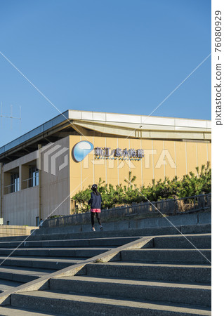 [Woman jogging in front of the Enoshima Aquarium by the sea] 76080929