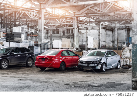Many wrecked car after traffic accident crash at restore service maintenance station garage indoor. Insurance salvage vehicle auction wholesale storage. Auto body wreck damage work workshop center 76081237