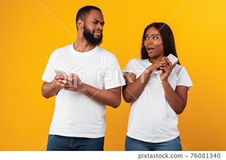 Black man checking his girlfriend mobile phone Black man checking his girlfriend mobile phone 76081340