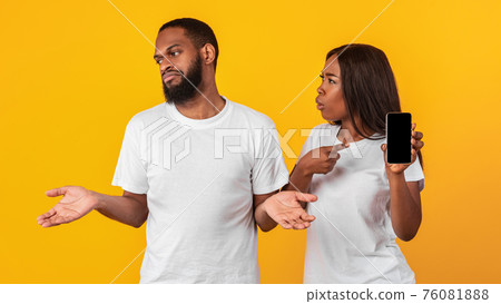 Black woman checking her boyfriend mobile phone Black woman checking her boyfriend mobile phone 76081888