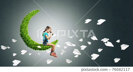 Concept of careless happy childhood with girl on green moon Concept of careless happy childhood with girl on green moon 76082117
