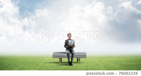 Young businessman or student studying the science in summer park Young businessman or student studying the science in summer park 76082238