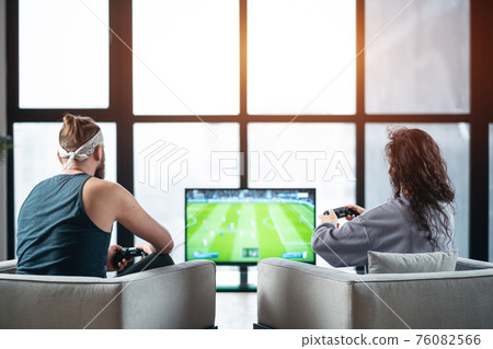 happy couple playing video game with controller on play station at home happy couple playing video game with controller on play station at home 76082566