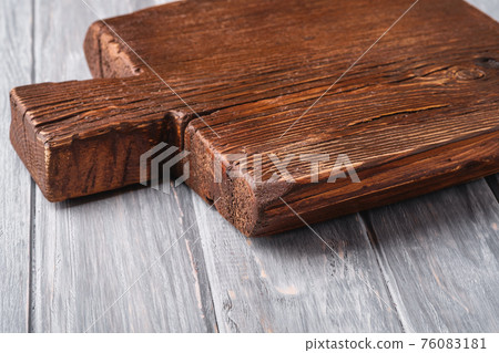 Handcraft dark brown teak wooden old cutting board, grey background, angle view selective focus Handcraft dark brown teak wooden old cutting board, grey background, angle view selective focus 76083181