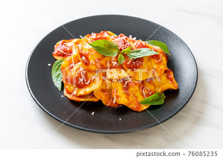Ravioli with tomato sauce and basil 76085235