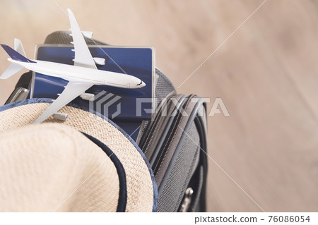 Lifestyle and traveling concept after quarantine Passports, hat and model airplane on gray suitcase 76086054