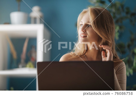Blonde with laptop at home Blonde with laptop at home 76086758