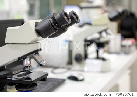 A microscope on a table in the laboratory. 76086761