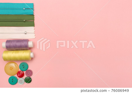 Sewing accessories on a colored background with copy space. Threads, zippers and buttons for clothes. Place for text. Sewing accessories on a colored background with copy space. Threads, zippers and buttons for clothes. Place for text. 76086949