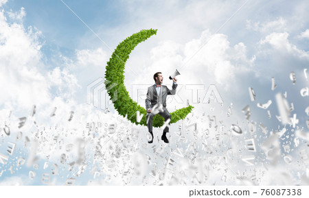 Businessman announcing something in loudspeaker and symbols fly around in air 76087338
