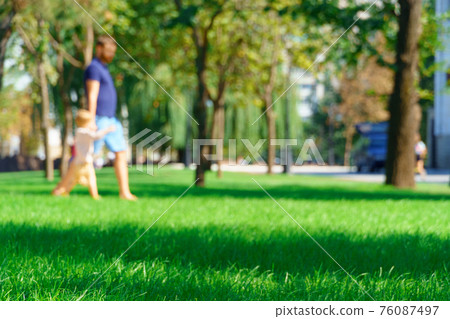 people walking and children playing in a city park on a summer day, green lawns with grass and trees, paths and benches, bright sunlight and shadows people walking and children playing in a city park on a summer day, green lawns with grass and trees, paths and benches, bright sunlight and shadows 76087497