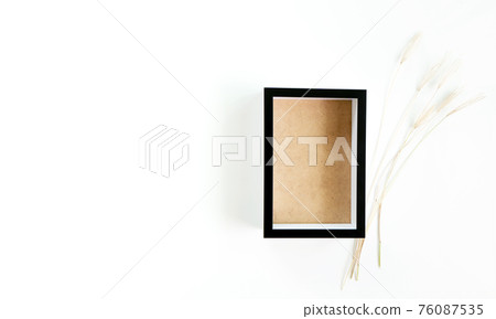 Black frame mockup with a grass flowers in a on a white background. Black frame mockup with a grass flowers in a on a white background. 76087535