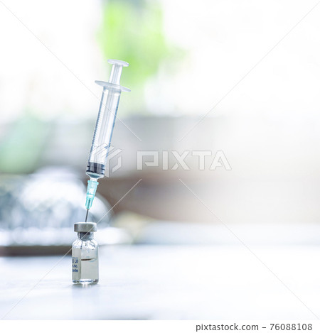 A syringe with the needle in the vaccine vial A syringe with the needle in the vaccine vial 76088108