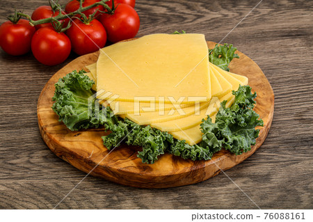 Sliced Gauda cheese over board 76088161