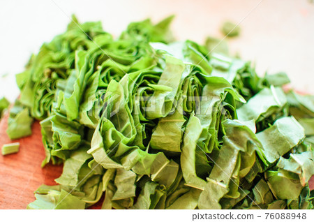 Fresh organic sorrel,plant spinach heap on wooden table for spring green vegetables soup and salad.Raw sorrel leaves top view green vegetable background.Spring green vegetables,sorrel spinach 76088948