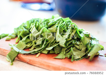 Young green sorrel sliced for borscht and salad lies on a cutting board, rustic style, in the morning in the sunlight. Copy space. 76088952