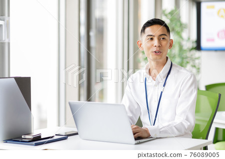 一個男人在筆記本電腦上工作 76089005
