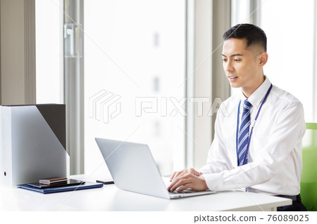 A man working on a laptop 76089025