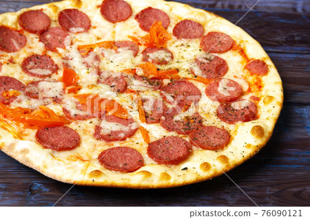 Pepperoni pizza with salami and mozzarellaon wooden table. 76090121