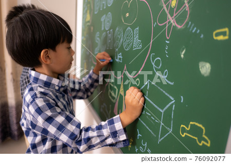 Asian littie boys write blackboard. 76092077