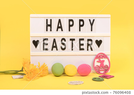 Happy Easter letters and easter eggs on yellow background Happy Easter letters and easter eggs on yellow background 76096408