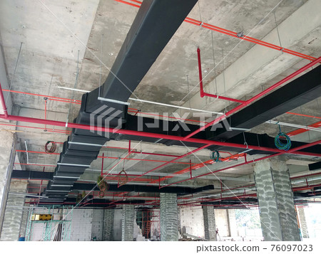 KUALA LUMPUR, MALAYSIA - SEPTEMBER 05, 2019: Mechanical and electrical services above ceiling level coordinated and installed by construction workers at the construction site.  76097023
