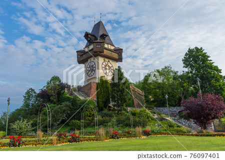 The famous clock tower (Grazer Uhrturm) and gardens on Shlossberg hill before sunrise,in Graz, Styria region, Austria The famous clock tower (Grazer Uhrturm) and gardens on Shlossberg hill before sunrise,in Graz, Styria region, Austria 76097401