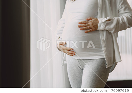 Pregnant woman hugging belly in anticipation of baby Pregnant woman hugging belly in anticipation of baby 76097619