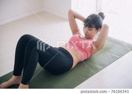 一個女人在做肌肉訓練、腹肌和節食的圖片 一個女人在做肌肉訓練、腹肌和節食的圖片 76100343