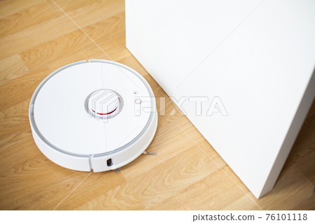 Vacuum cleaner robot runs on wood floor in a office Vacuum cleaner robot runs on wood floor in a office 76101118