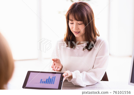 Business woman talking with a tablet PC Business woman talking with a tablet PC 76101556