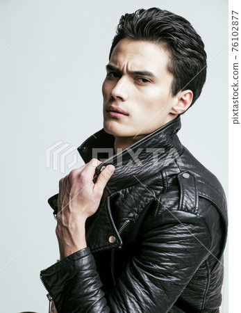 young handsome asian man, leather jacked on naked torso, emotional posing, lifestyle people concept 76102877