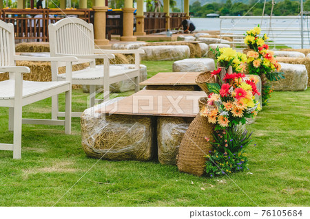Seats and tables made from straw bales for event and party laid on lawn yard. Straws stubble decorated for sitting in the countryside. Furniture made of pallets and straw bales. Selective focus. 76105684