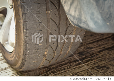 Old tire with worn tread and scratch 76106813