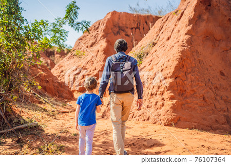 Dad and son tourists in red canyon, resumption of tourism concept. Traveling with children concept Dad and son tourists in red canyon, resumption of tourism concept. Traveling with children concept 76107364
