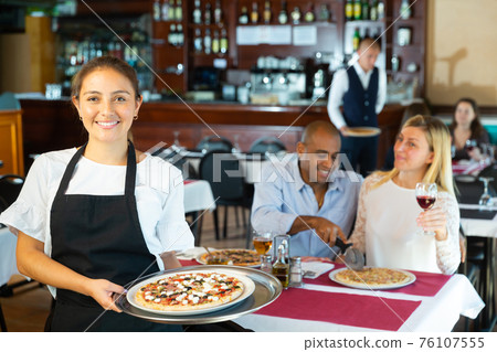 Portrait of waitress with serving tray pizza offering dishes Portrait of waitress with serving tray pizza offering dishes 76107555