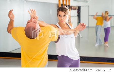 Woman practicing basic palm strike in self defense training Woman practicing basic palm strike in self defense training 76107906