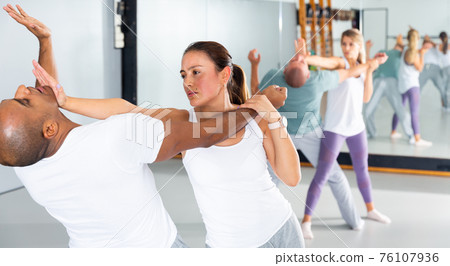 Hispanic girl using palm to launch blow in chin during self defence training Hispanic girl using palm to launch blow in chin during self defence training 76107936