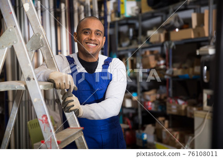 Positive Latin American workman in wareroom of construction hypermarket 76108011