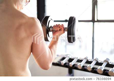 Asian man lifting dumbbells backwards 76108094