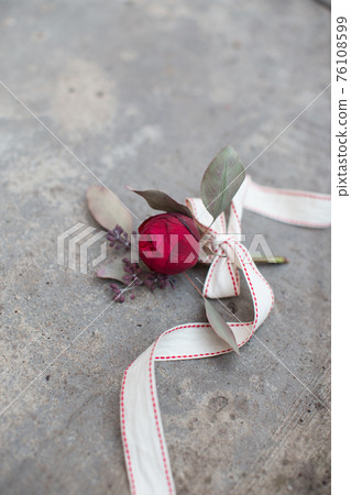 Red rose with ribbon on the concrete ground 76108599