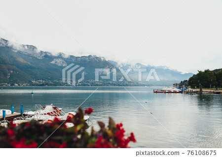 Annecy lake view from Annecy city, red flowers 76108675